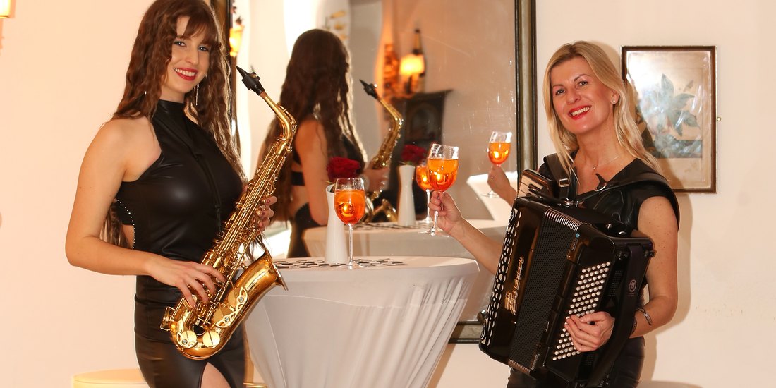 Zum Sektempfang: Andrea Wittmann mit dem Akkordeon und Viviana mit dem Saxofon an einem Stehtisch